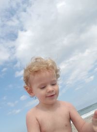 Portrait of shirtless boy in sea against sky
