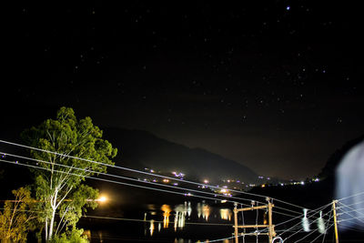 Illuminated suspension bridge against sky at night