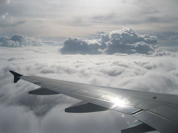 View of airplane wing over clouds