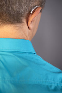 Close-up rear view of man against blue background