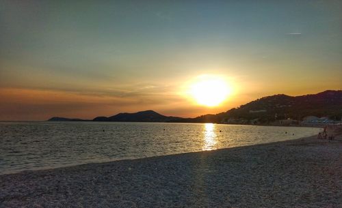 Scenic view of beach against sky during sunset