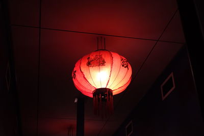 Low angle view of electric lamp hanging on ceiling