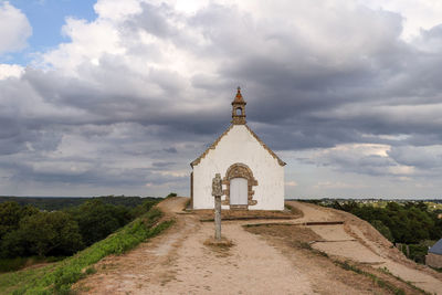 View of cross on landscape against sky