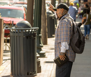 Side view of man standing on street, preaching