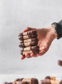 Close-up of hand holding stack against white background