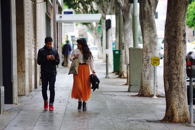 Rear view of people walking on footpath