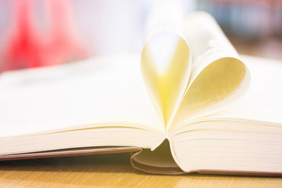 Close-up of book pages forming heart shape on table