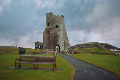 Old ruin on field against cloudy sky