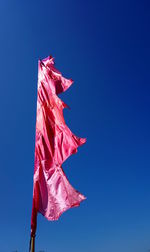 Low angle view of flag against blue sky