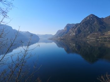 Scenic view of lake and mountains against clear blue sky