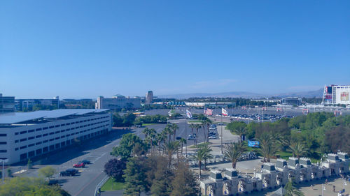 High angle view of street and buildings against clear blue sky