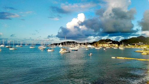 Sailboats moored in sea against sky