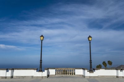 Low angle view of street lights against blue sky