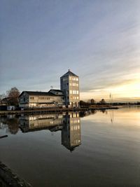 Reflection of building in lake against sky