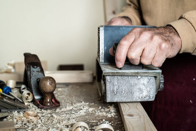 Midsection of carpenter working on wood