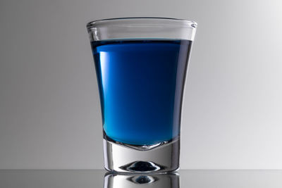 Close-up of blue glass against white background