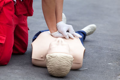 Midsection of paramedic performing cpr on dummy