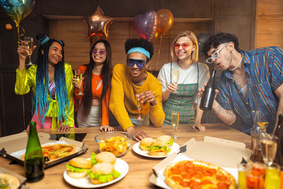 Portrait of smiling friends with food at restaurant