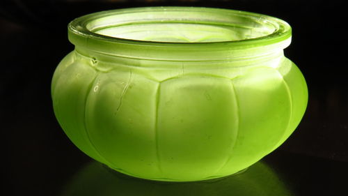 Close-up of green jar on table