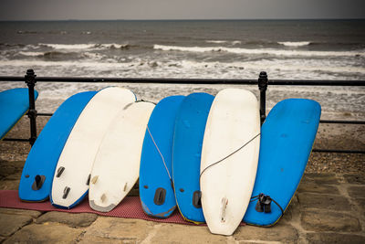 Deck chairs on beach against blue sky