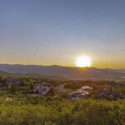 High angle view of houses on field against sky during sunset