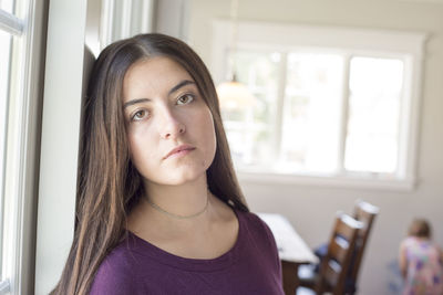 Portrait of beautiful young woman sitting in kitchen