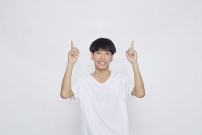 Portrait of smiling man standing against white background