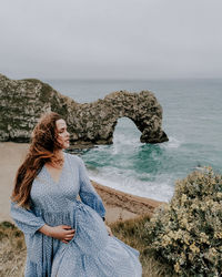 Woman standing at beach against clear sky