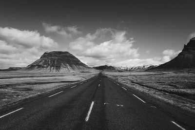 Empty road by mountain against sky