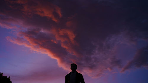 Rear view of silhouette man standing against sky during sunset