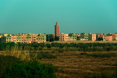 Buildings on field against clear sky