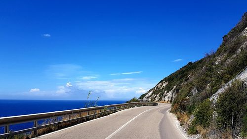 Empty road against blue sky