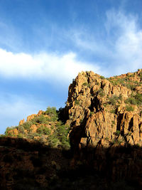 Low angle view of rock formation against cloudy sky