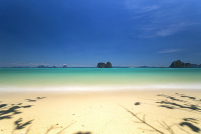 Scenic view of beach against blue sky