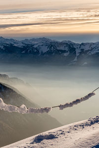 Scenic view of snow covered mountains against sky during sunset