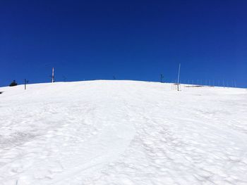 Scenic view of snowcapped field against clear blue sky