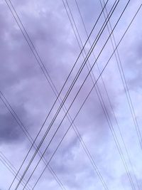 Low angle view of power cables against sky