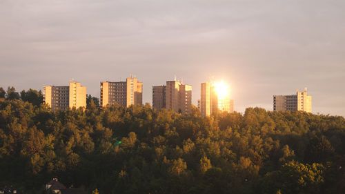 Beautiful warm sunset in neutral orange tones with sun reflection on soviet residential high rise 