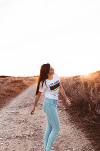 Full length of woman standing on land against sky