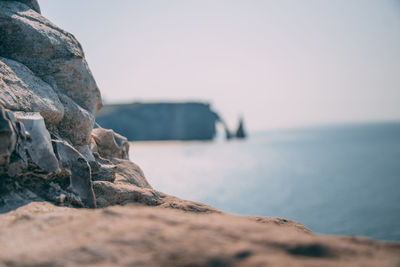 Rock formation on beach against sky