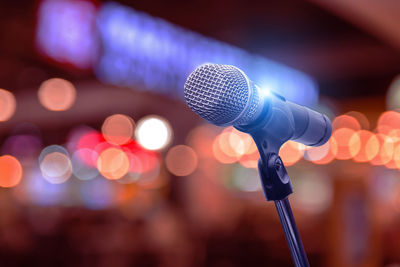 Close-up of microphone against illuminated lights