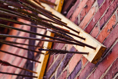 Incense sticks on wooden plank mounted on brick wall