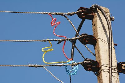 Low angle view of cables against clear blue sky