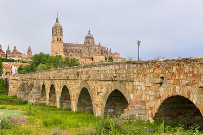 Arch bridge over land against sky