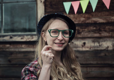 Portrait of smiling young woman holding eyeglasses prop