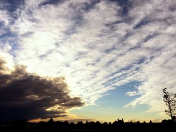 Silhouette landscape against cloudy sky