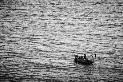 People in boat sailing on sea
