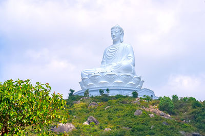 Low angle view of statue against trees and sky