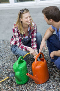 Young couple filling watering cans, stockholm, sweden
