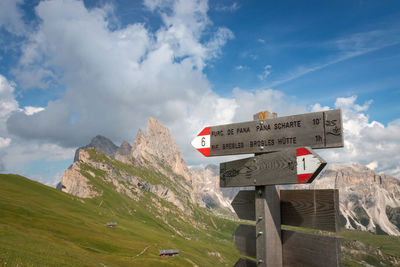 Information sign on mountain against sky